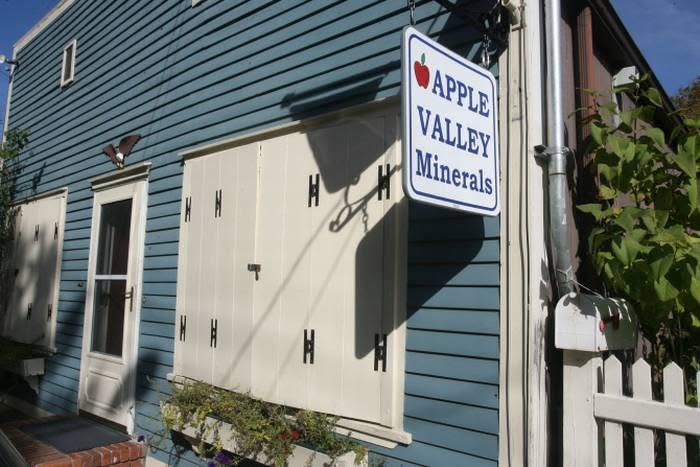 The blue exterior of Apple Valley Minerals with its hanging shop sign